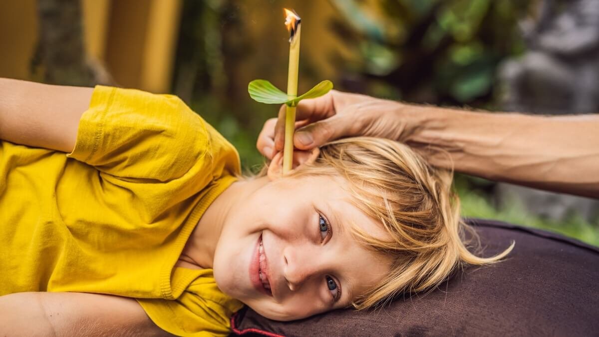 Apžvelgiama Šiluminė Ausų Terapija – arba „Ear Candling“. Iliustracijoje matome, kaip taikoma Šiluminė ausų terapija dar kitaip vadinama Ear Candling vaikui.