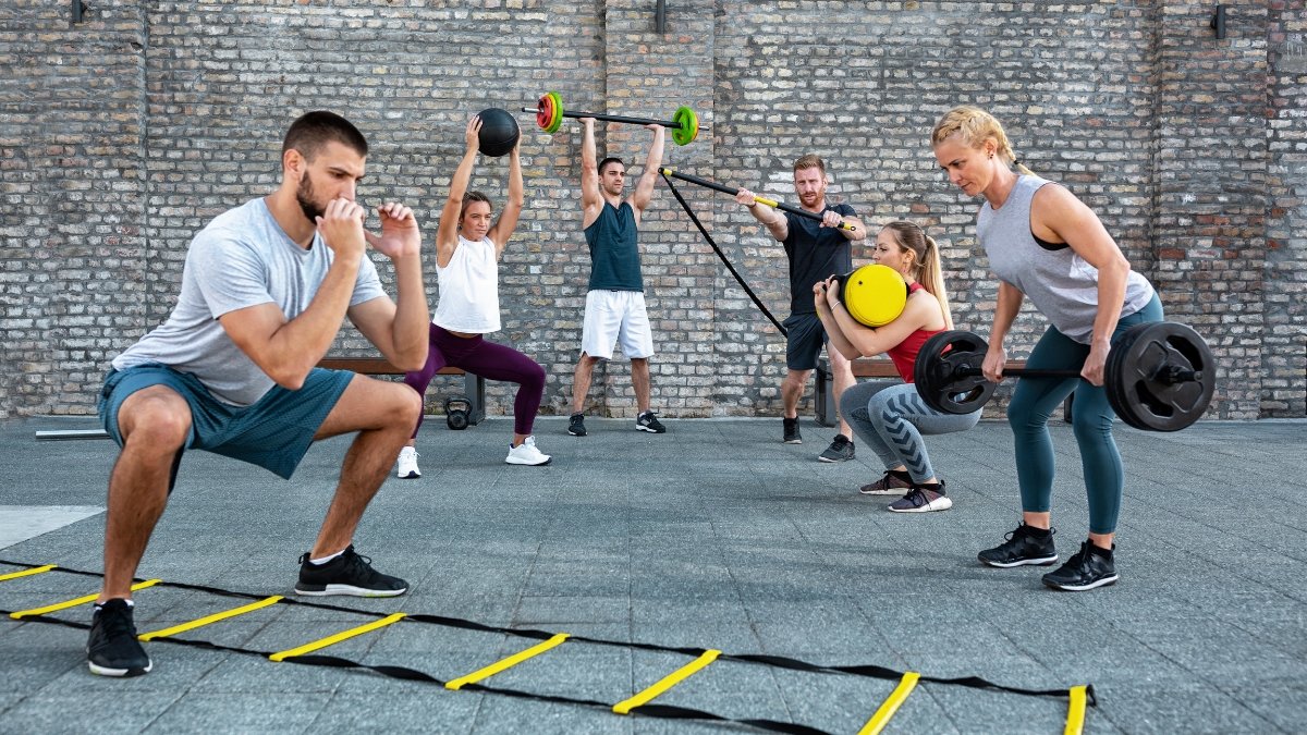 Judrumo Kopėčios (Agility Ladder). Daugybe sportininku sportuojančių lauke.
