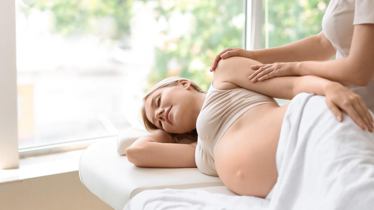 Pateikiama video nuoroda apie nėščiųjų masažą iš knygos Pre- and Perinatal Massage Therapy: A Comprehensive Guide to Prenatal, Labor and Postpartum Practice. Paveiksliuke matome nėščią moterį, kuria atliekam procedūra.