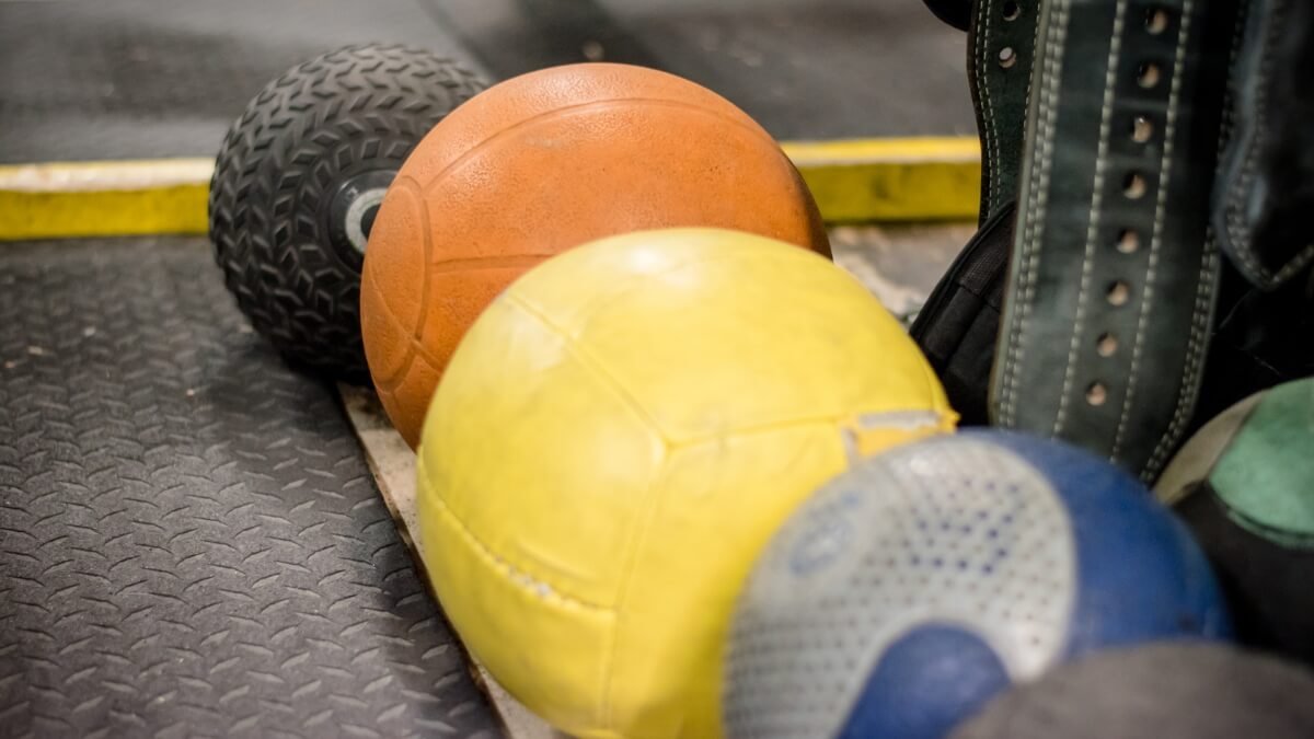 Medicininio Kamuolio Pratimų Veiksmingumas (Medicine Ball). Pateikta iliustracija kur grupė žmonių mankštinasi naudojant medicininius kamuolius.