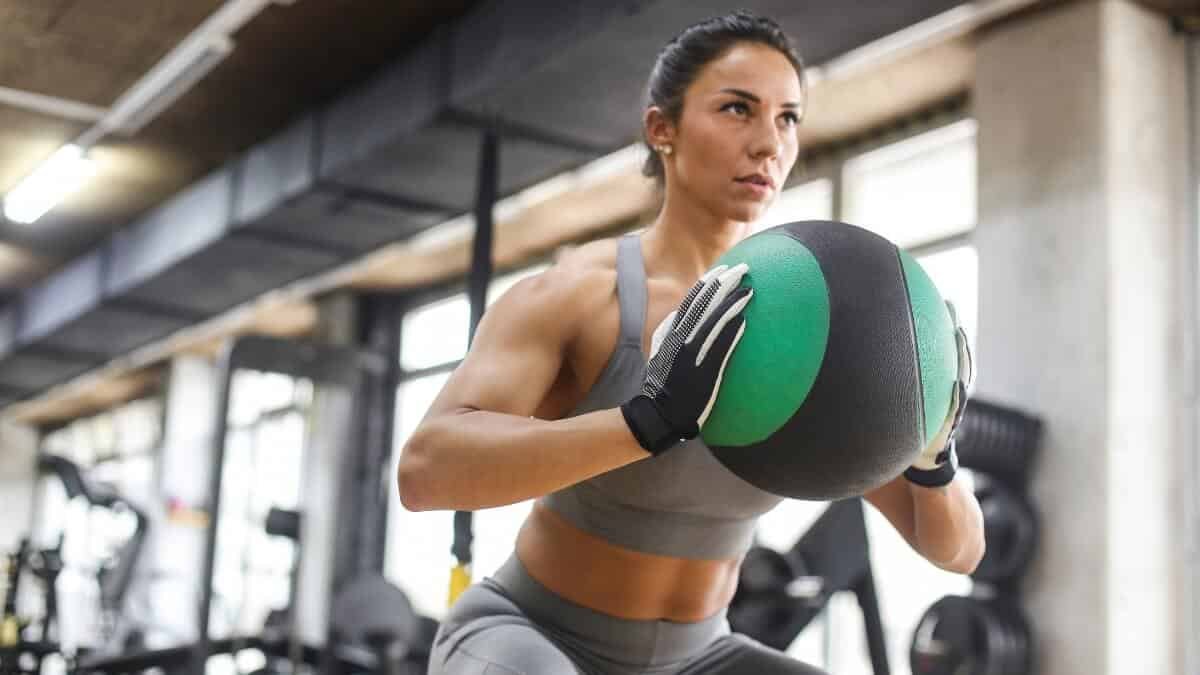Medicininio Kamuolio Pratimų Veiksmingumas (Medicine Ball). Pateikta iliustracija kur mergin sportuoja naudodami medicininį kamuolį.