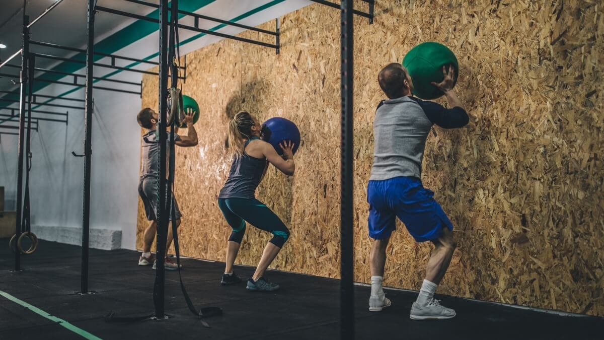 Medicininio Kamuolio Pratimų Veiksmingumas (Medicine Ball). Pateikta iliustracija kur grupė žmonių mankštinasi naudojant medicininius kamuolius.