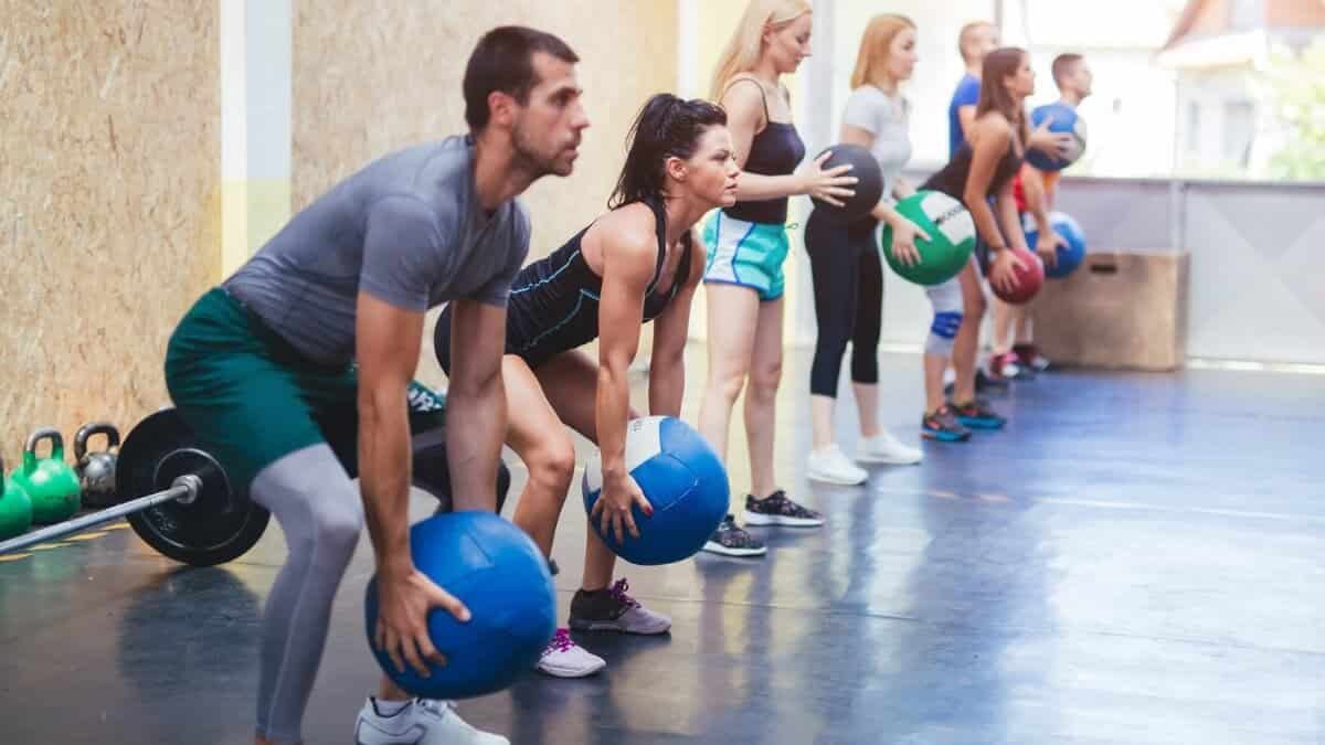 Medicininio Kamuolio Pratimų Veiksmingumas (Medicine Ball). Pateikta iliustracija kur grupė žmonių mankštinasi naudojant medicininius kamuolius.