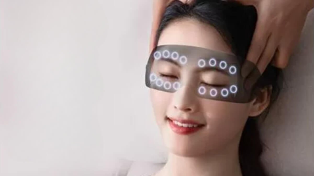 Akių Masažuoklis HXR-P060 (Eye Massager HXR-P060). Pateiktas Akių Masažuoklis HXR-P060 kuris yra uždėtas ant moters veido.