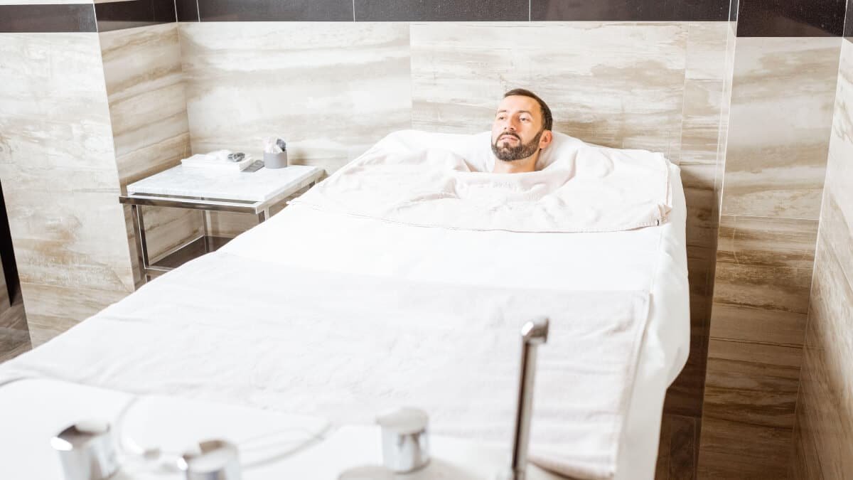 Angliarūgštės Mineralinė Vonia (Carbonated Mineral Bath). Vyras guli vonioje kur jam atliekama angliarūgštes mineralinė procedūra.
