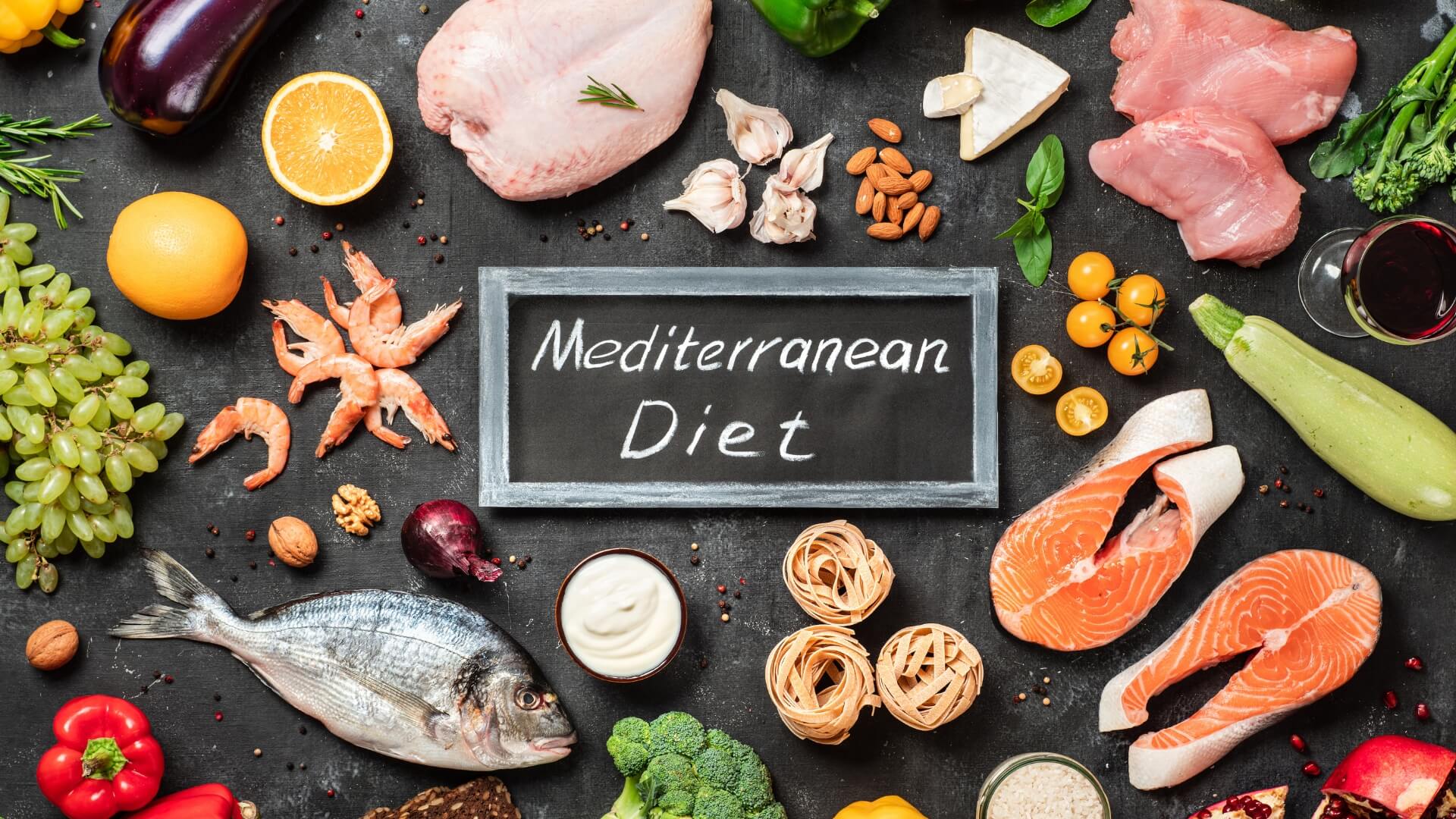 Viduržemio Jūros Dieta (Mediterranean Diet) Viduržemio Jūros Dieta (Mediterranean Diet). Viduržemio jūros dietos maisto produktai – žuvis, jūros gėrybės, daržovės, vaisiai, riešutai, makaronai ir alyvuogių aliejus, išdėlioti aplink užrašą „Mediterranean Diet“.