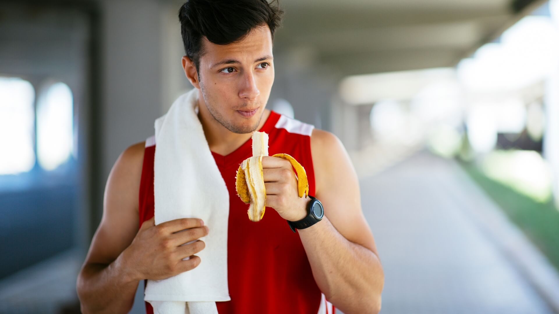Angliavandeniai Ir Raumenys (Carbs And Muscles) Angliavandeniai Ir Raumenys (Carbs And Muscles). Sportininkas valgo bananą po treniruotės – angliavandeniai energijai ir raumenų atsistatymui.